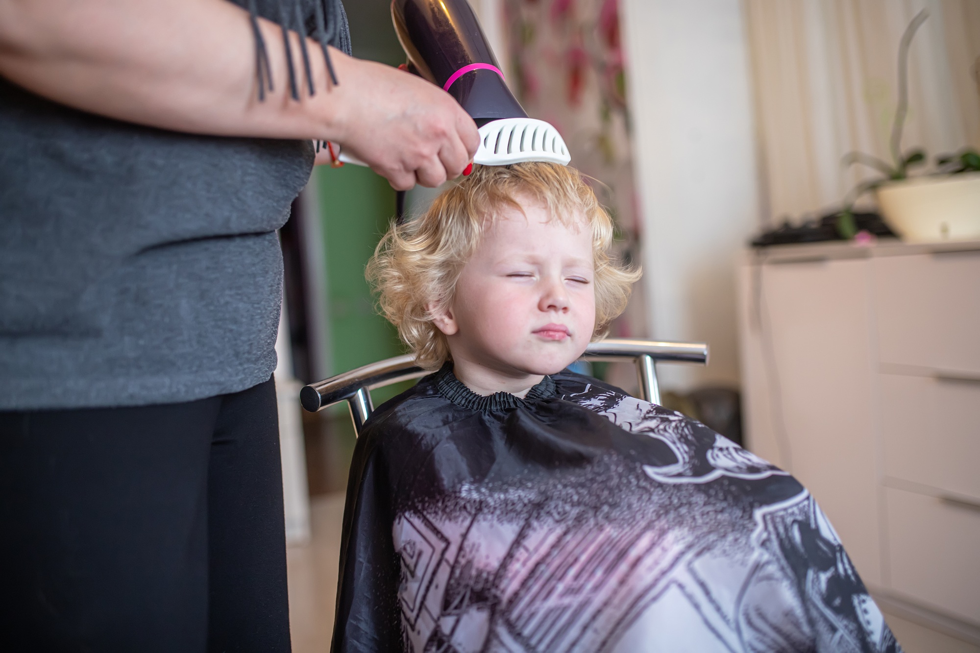 Inicio 7 A little curly girl with blonde hair in a beauty salon. Haircut children. Children's hairdresser